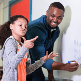 Male teacher at whiteboard with student