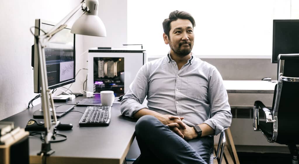 Man sitting at corner desk in a group workstation