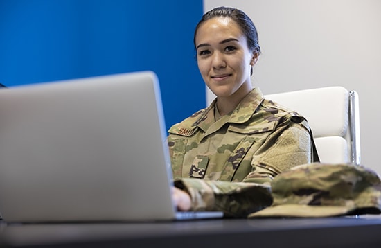 Una mujer militar de la Fuerza Aérea en la oficina con una computadora