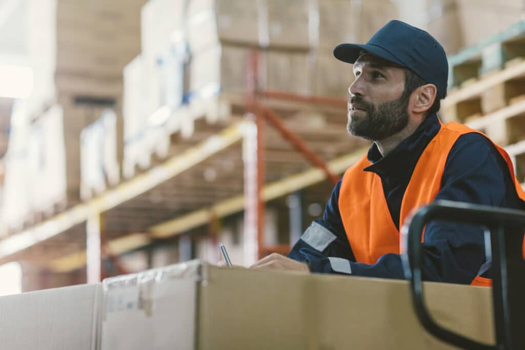 Manual worker in warehouse checking merchandise