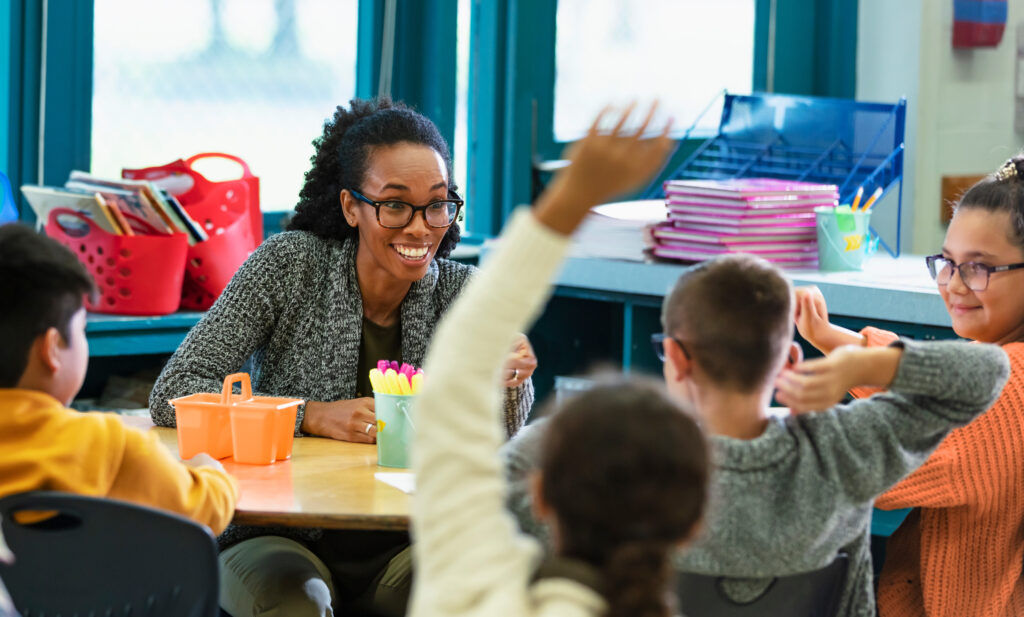 Enseignant suppléant discutant avec des élèves du primaire.