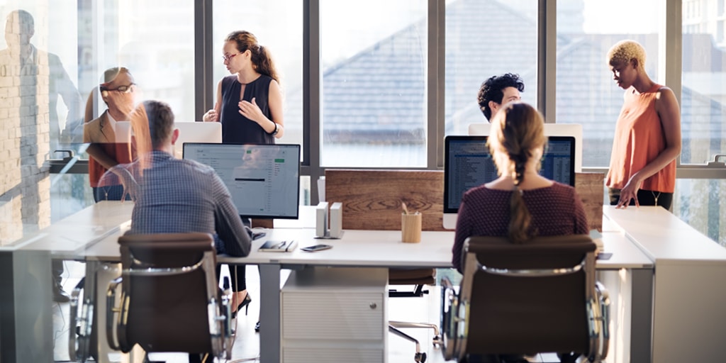 office setting with people working on laptops at a table